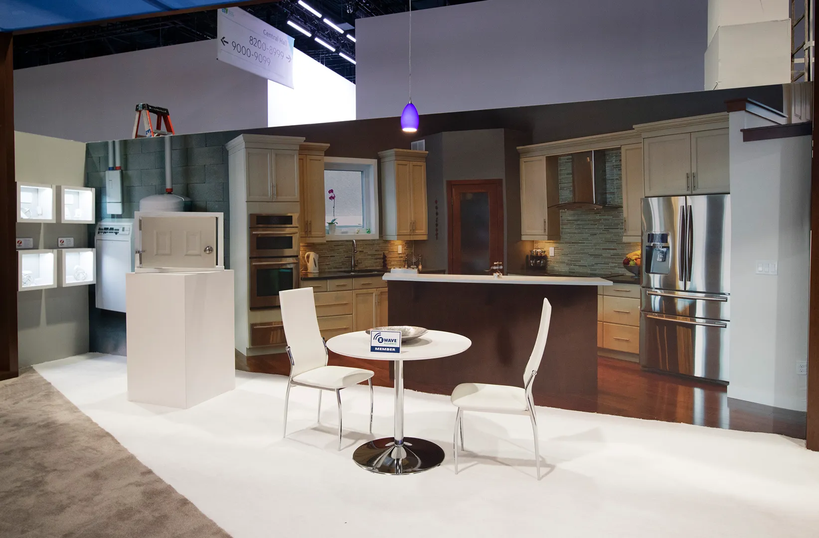 A white table and two chairs sits in the middle of a fake set that looks like a house.